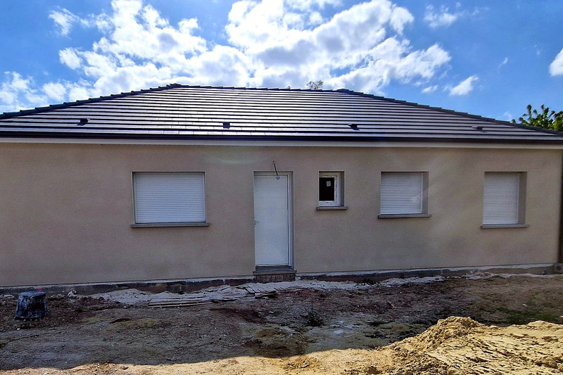 Maison neuve plain-pied à toiture quatre pans, enduit ton pierre